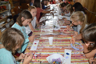 Abends sitzen alle Kinder in lustiger Runde zusammen und basteln